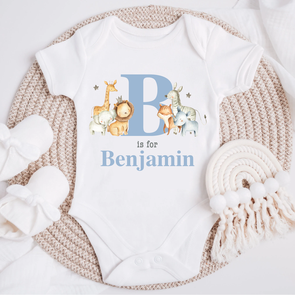 Personalised baby jungle safari animal vest in blue powder, featuring an initial and name' design with adorable illustrations of a giraffe, lion, fox, elephant and zebra on a white bodysuit. Perfect for newborns to 12 months.
