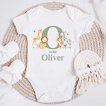Personalised baby jungle safari animal vest in olive green, featuring an initial and name' design with adorable illustrations of a giraffe, lion, fox, elephant and zebra on a white bodysuit. Perfect for newborns to 12 months.